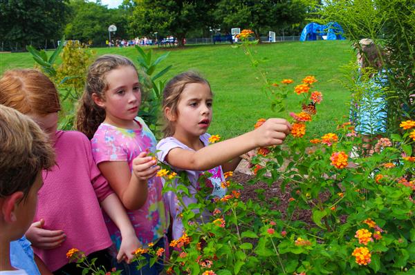 students in a flower garden with butterflies